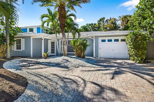 a white house with a garage and palm trees at Lantana Cabana in Clearwater Beach