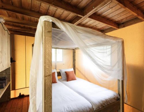 a bedroom with a bed with a mosquito net at F1 Weekend House Close to Spa 6 Guests Doc in Amblève