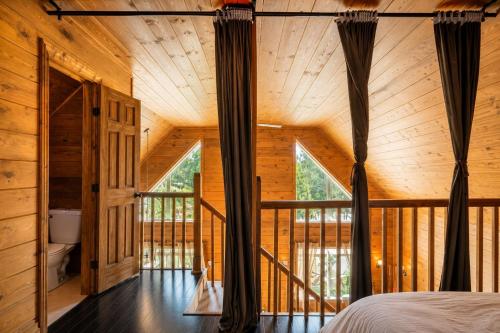 a bedroom in a log cabin with a large window at Le Malpic in Mont-Laurier