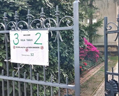 a sign on a gate in front of a bush at Villa Taxus-Smokers not welcome in Dresden