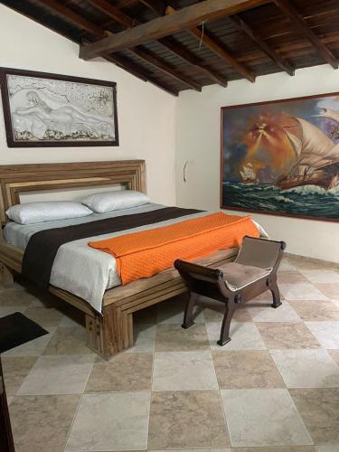 ein Schlafzimmer mit einem Bett mit einer orangefarbenen Decke in der Unterkunft casa serrano in Valledupar
