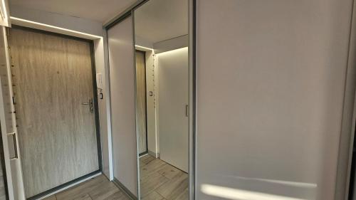 a hallway with a glass door and a mirror at Studio w kamieniczce in Konstantynów Łódzki