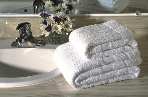 a white towel sitting on top of a bathroom sink at Branding Iron Motel in Chama