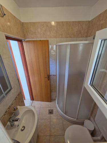 a bathroom with a shower and a sink and a toilet at Apartments Mikecin in Novigrad Dalmatia