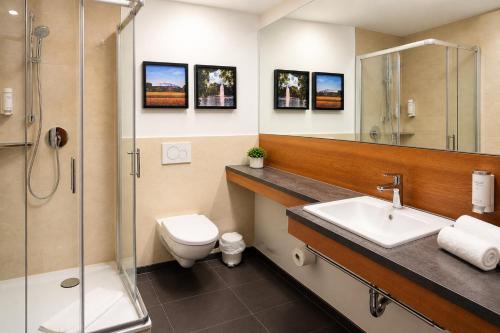a bathroom with a toilet and a sink and a shower at FlexInn Hotel Gelsenkirchen in Gelsenkirchen