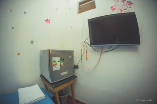 a flat screen tv hanging on a wall at VOY Hostales - Oriente in Viña del Mar