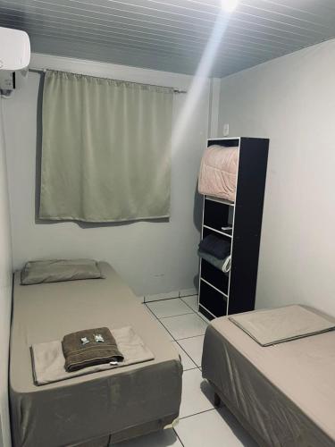 a small room with two beds and a window at Hotel Real in Realeza