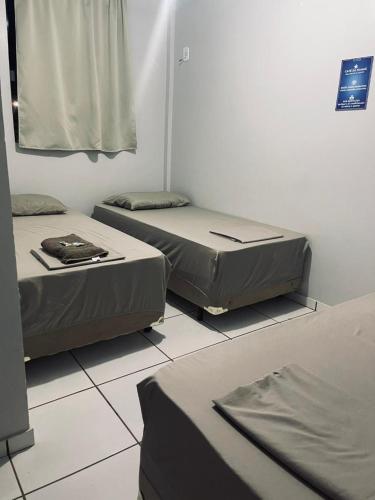 a room with two beds on a tiled floor at Hotel Real in Realeza
