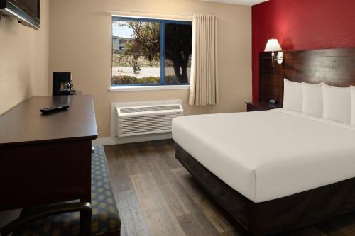 a bedroom with a white bed and a desk and a window at Bay Breeze Inn in Seaside