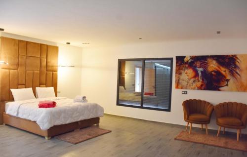 a bedroom with a large bed and two chairs at Villa Dar SAYF in Najem