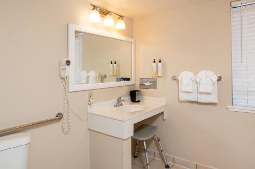 a white bathroom with a sink and a mirror at Bay Breeze Inn in Seaside