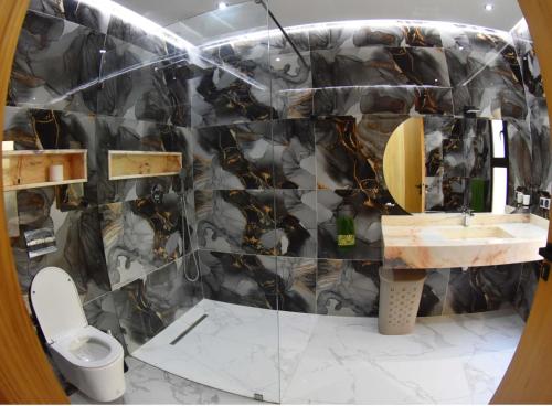 a bathroom with a black and gold patterned wall at Villa Dar SAYF in Najem