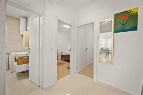 a white hallway with a door leading to a bedroom at New luxury apartment RABASOL in Rabac