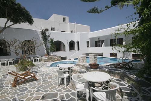 a patio with tables and chairs in front of a building at Atlantis Hotel in Naousa