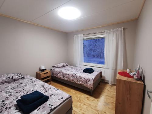 a bedroom with two beds and a window at Aurora House in Pello
