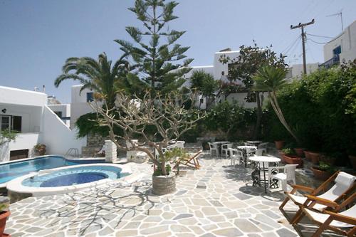 a patio with a tree and a swimming pool at Atlantis Hotel in Naousa