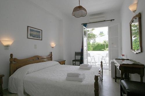 a bedroom with a bed and a desk and a window at Atlantis Hotel in Naousa