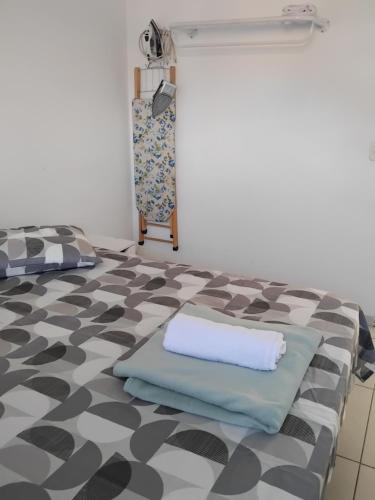 a room with a bed with a pillow on the floor at EM CASA in Palhoça