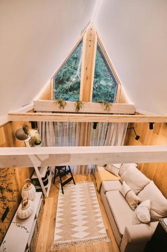 an attic room with a large window and a couch at OLA I Oáza Les Atmosféra I Oasis Forest Atmosphere in Petrov