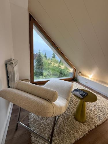 a room with a chair and a table and a window at Luxury Housing in Formigal in Formigal