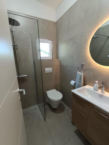 a bathroom with a shower and a toilet and a sink at Villa Paradiso in Ohrid