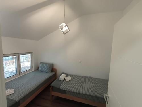 a small room with two beds and a window at Villa Paradiso in Ohrid