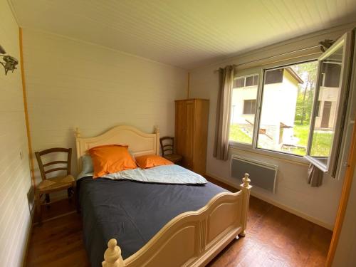 a bedroom with a bed with orange pillows and a window at Oustau deu Beç in Verdaches