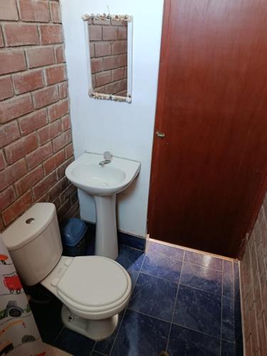 a bathroom with a toilet and a sink at Jandys house Lobitos in Barrio Bellavista