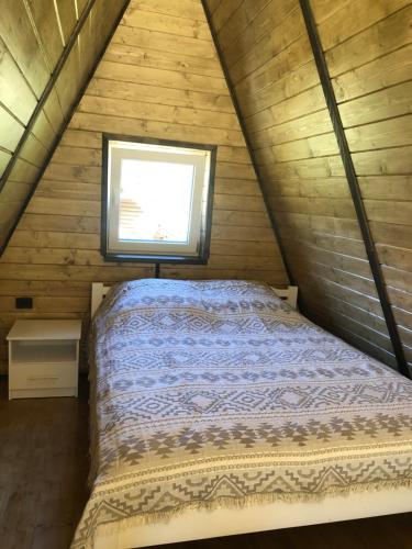 a bed in a small room with a window at Frame&Forest2 in Kolochava