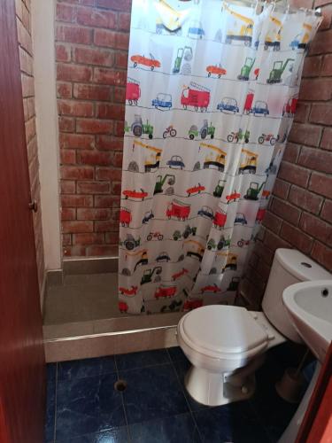 a bathroom with a toilet and a shower curtain at Jandys house Lobitos in Barrio Bellavista