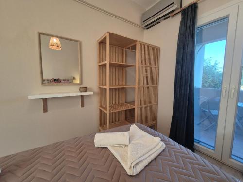 a bedroom with a bed and a mirror and a window at Maresia Apts & Studios in Arillas
