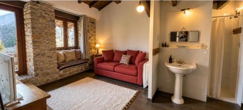 a living room with a red couch and a sink at Casa do Tio Zé Montesinho in Montezinho