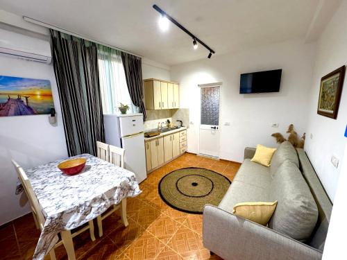 a living room with a couch and a table and a kitchen at Joni's Beach Apartments - Spille in Spille