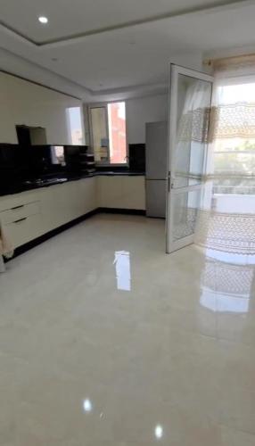 an empty room with a kitchen with a refrigerator at Appartamento spazioso e luminoso in Mahdia