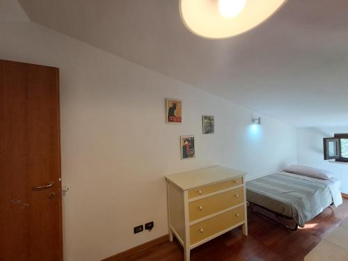 a bedroom with a bed and a dresser and a light at Casa Panorama Assisi in Perugia