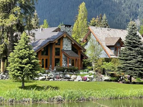 a log cabin in the woods next to a lake at 8140 Nicklaus North in Whistler