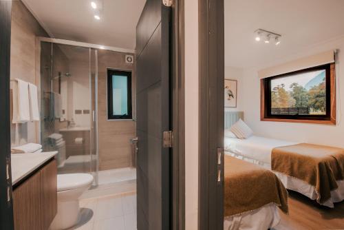 a bathroom with a bed and a toilet and a shower at Cabañas Parque Futangue in Lago Ranco