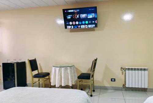 a hospital room with a table and chairs and a tv at Hostal Face in La Paz