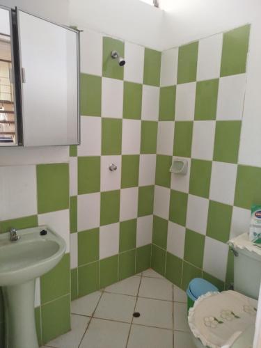 a bathroom with a green and white checkered wall at Casa de 2 pisos en Morales in Morales