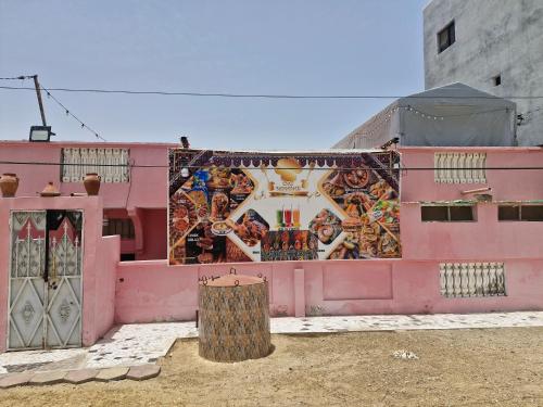 a pink building with a mural on the side of it at El khaïma in Saint-Louis