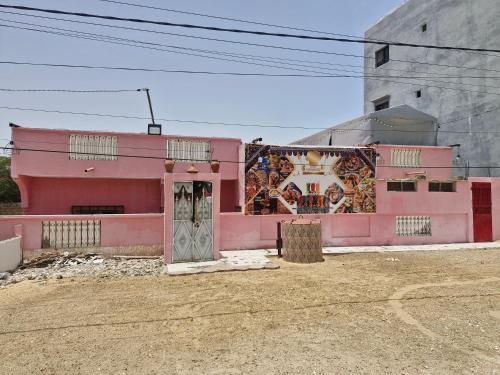 a pink building with a mural on the side of it at El khaïma in Saint-Louis