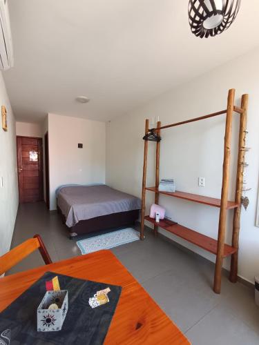 a bedroom with a bed and a table in a room at Residencial Lucernaré - Tiririca in Itacaré