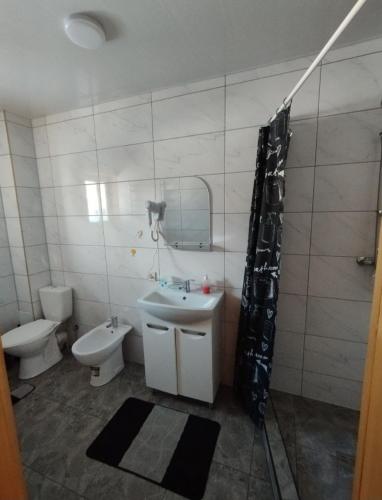 a bathroom with a sink and a toilet and a mirror at Гостинний двір in Vorokhta