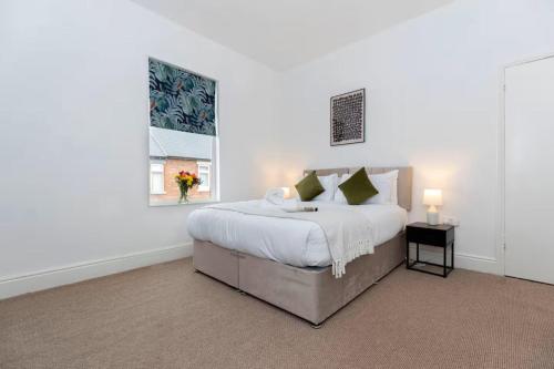 a white bedroom with a large bed and a window at 3BR Home in Darlington Contractor Rates in Darlington