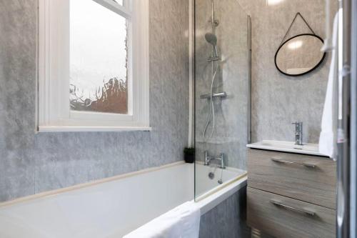 a bathroom with a tub and a sink and a window at 3BR Home in Darlington Contractor Rates in Darlington
