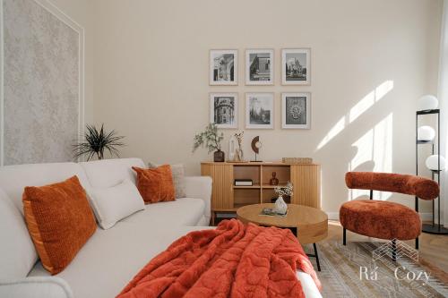 a living room with a white couch and a table at Rá-Cozy in Pécs