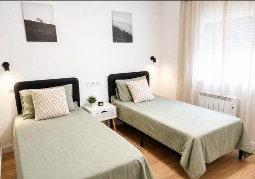 two beds sitting next to each other in a bedroom at House with a private pool, relaxation guaranteed in Talavera de la Reina