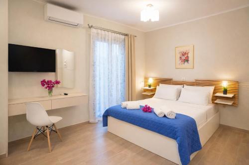 a bedroom with a bed and a chair and a television at Nikoletta 5 in Vlachopoulátika