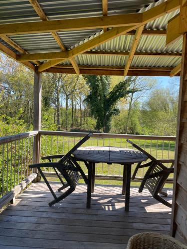 a wooden deck with a picnic table and two chairs at Zambezi Cabin in Halesworth