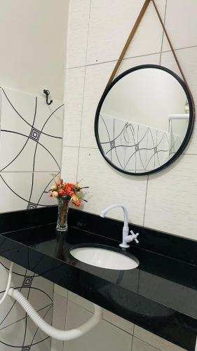 a bathroom with a sink and a mirror at Pousada Girassol in Piranhas